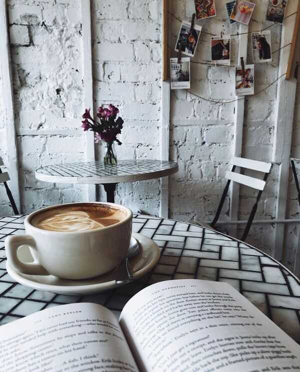 Libro abierto y una taza sobre una mesa clara en un ambiente tranquilo
